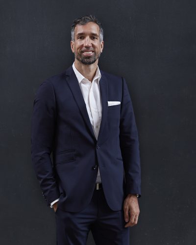Marcus Florek, Vorstand der Luana AG, steht vor schwarzem Hintergrund im dunklen Anzug und mit weißem Hemd und lächelt in die Kamera.