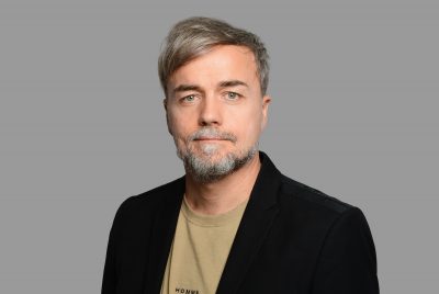 Portrait with grey background of Bastian Laschkowski
